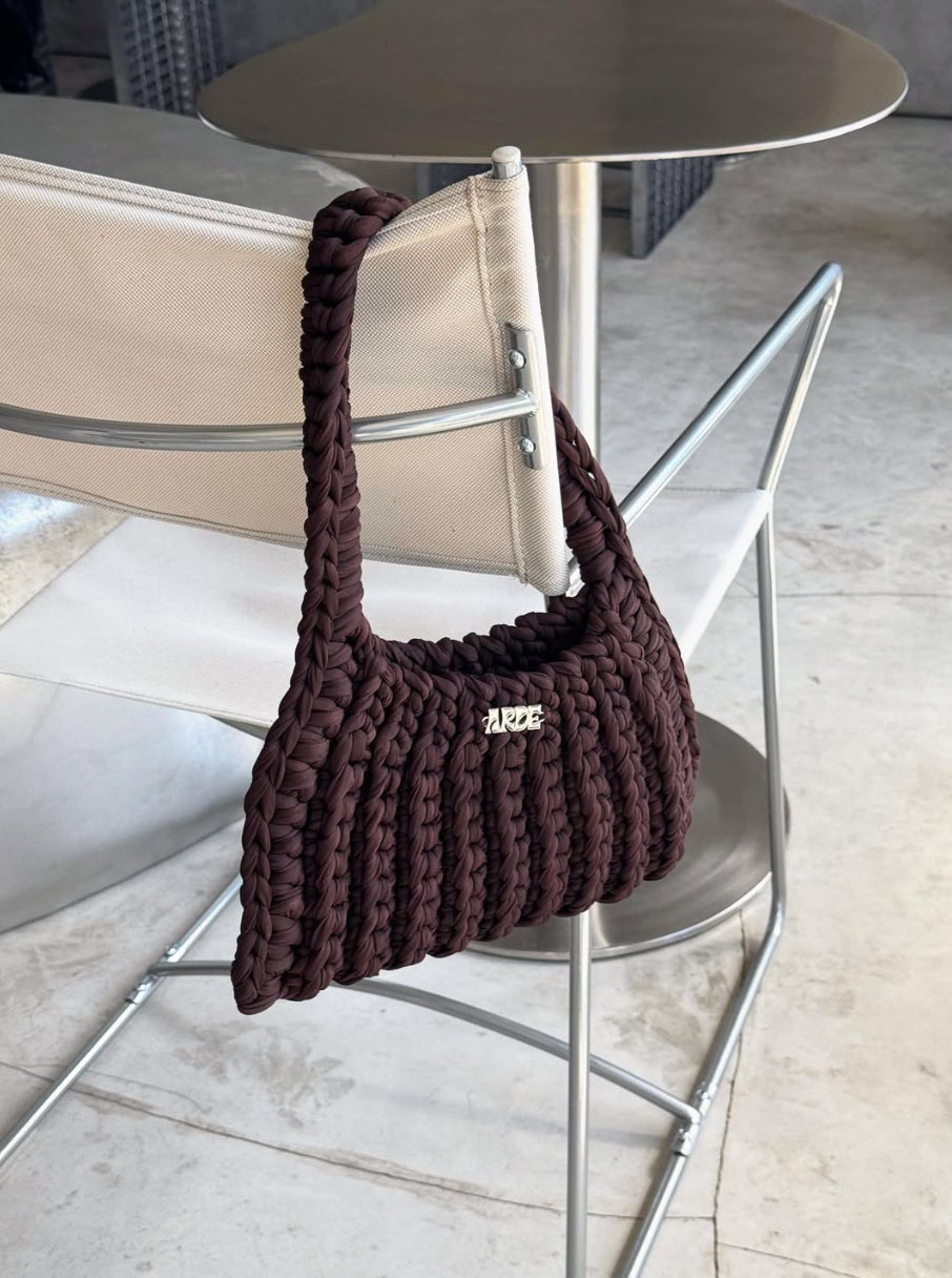 Brown knitted handbag on a metal chair in Melbourne