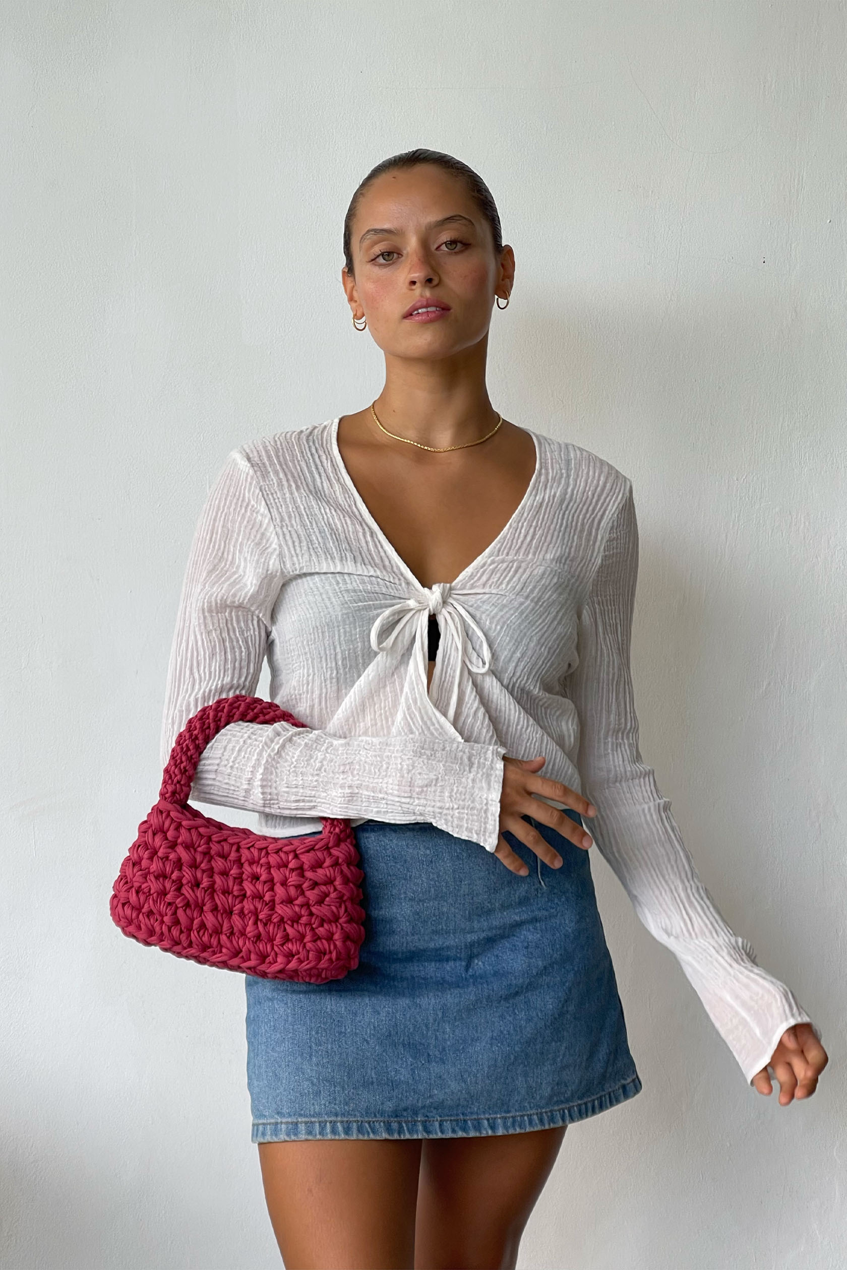 Beatiful Woman Wearing A Volcan Mini Bag In Rouge Colour Looking At The Camera
