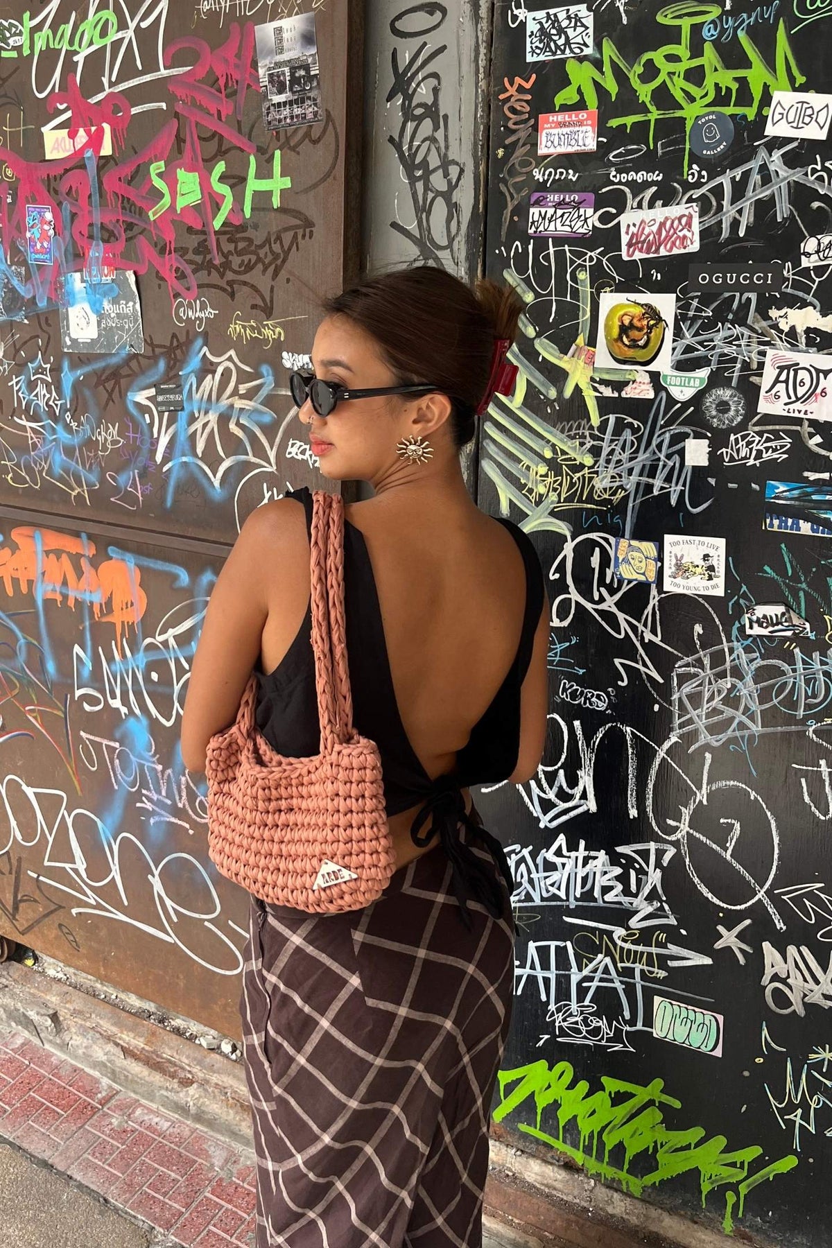Woman choosing a personal style look with a handmade crochet bag