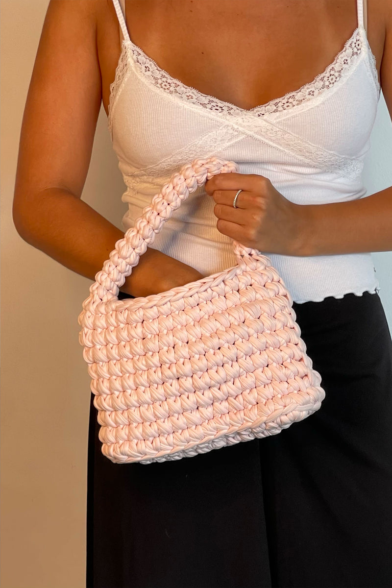 Woman With Her Hand Inside A Baby Pink Mini Bag