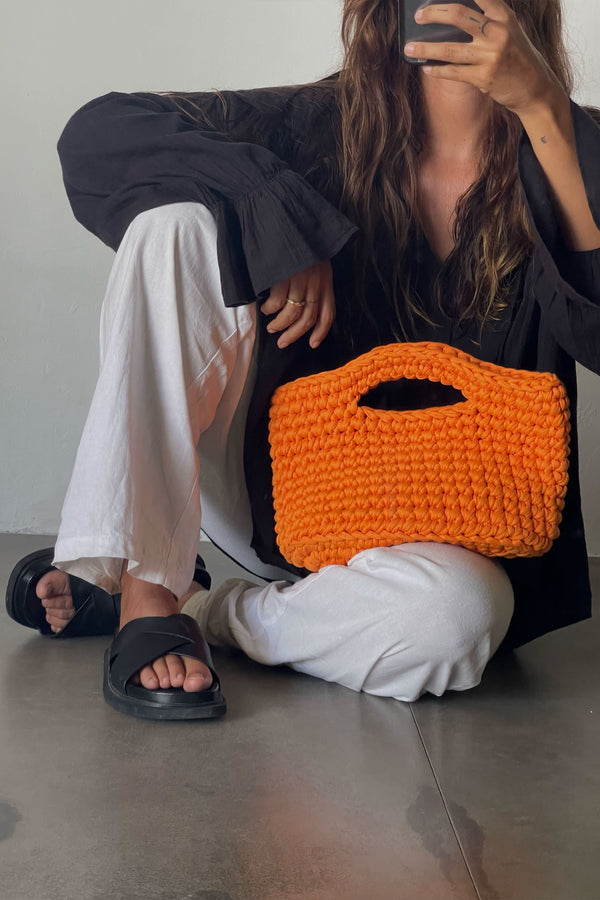 Stylish Woman Sitting With Crocheted Orange Basket